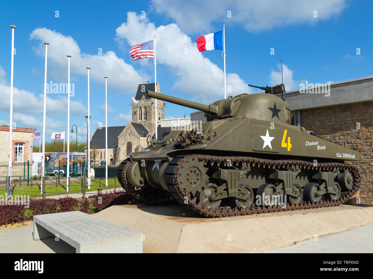 Sainte Mere Eglise, Frankreich - 5. Mai 2019: M4 Sherman Panzer an das Airborne Museum, mit der Kirche von Sainte Mere Eglise, wo ein Soldat hängt Fro Stockfoto