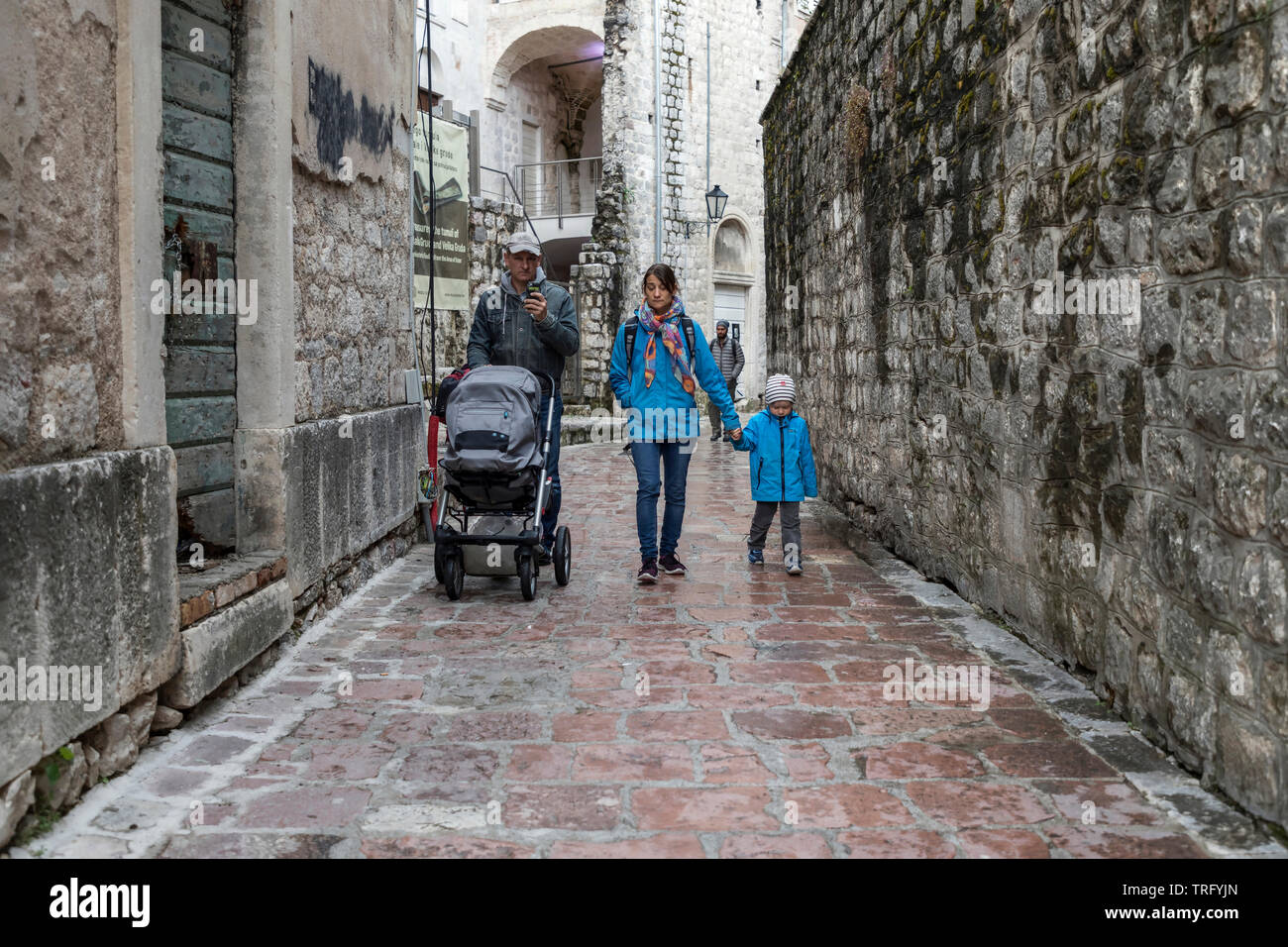 Montenegro, 30. April 2019: Eine Familie, die die enge Kopfsteinpflasterstraße in der Altstadt von Kotor entlang geht Stockfoto