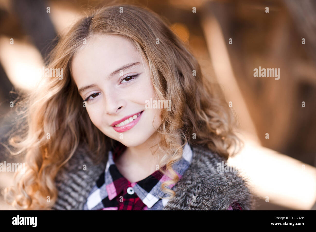 Portrait von Teenage blonde Mädchen 14-15 Jahr alt mit langen Locken im Freien. Mit Blick auf die Kamera. Stockfoto