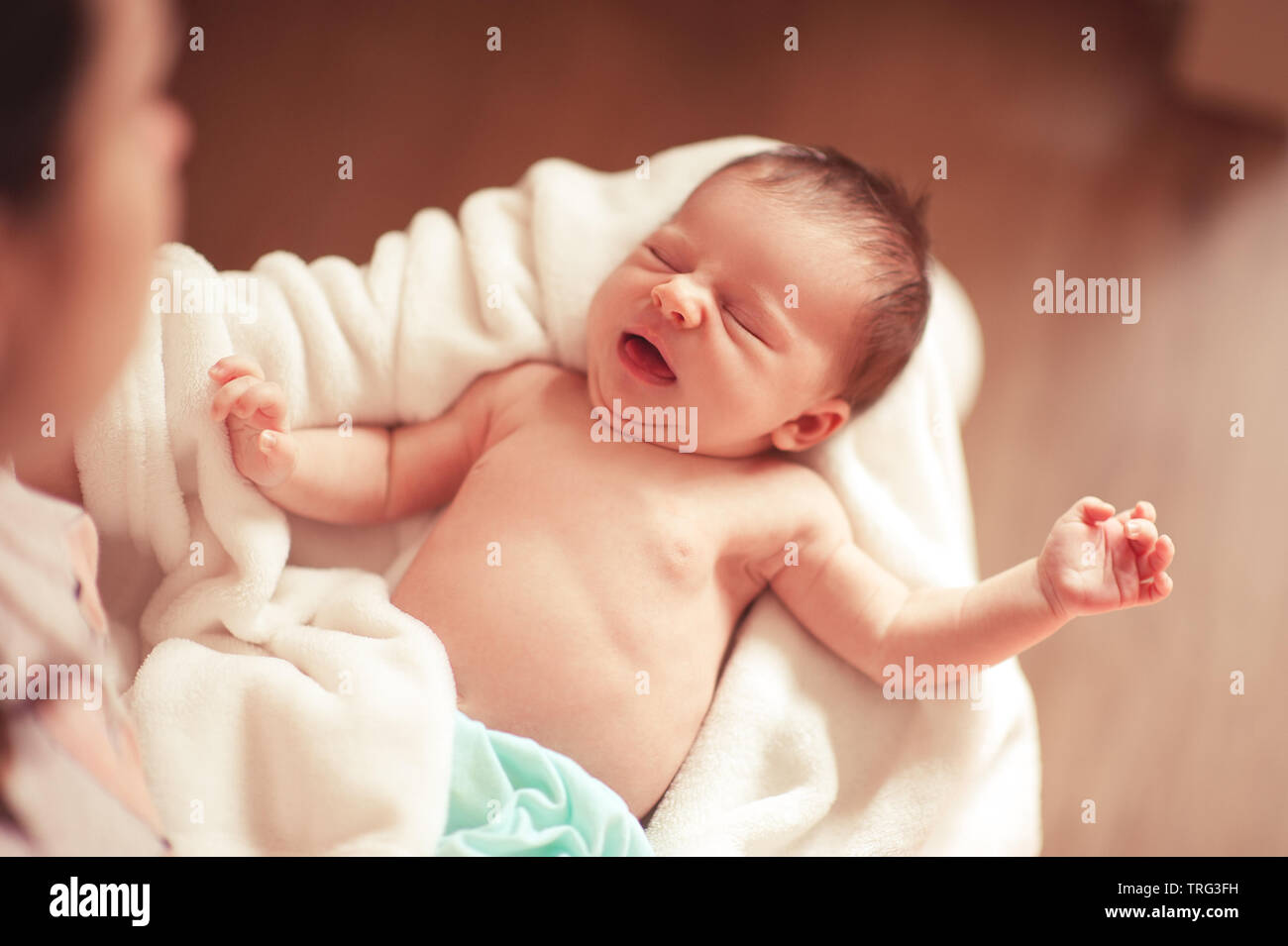 Mutter Holding Baby schreien Mädchen Aufwachen auf ihre Hände Nahaufnahme. Frau mit Kind Mädchen. Die Mutterschaft. Ansicht von oben. Stockfoto