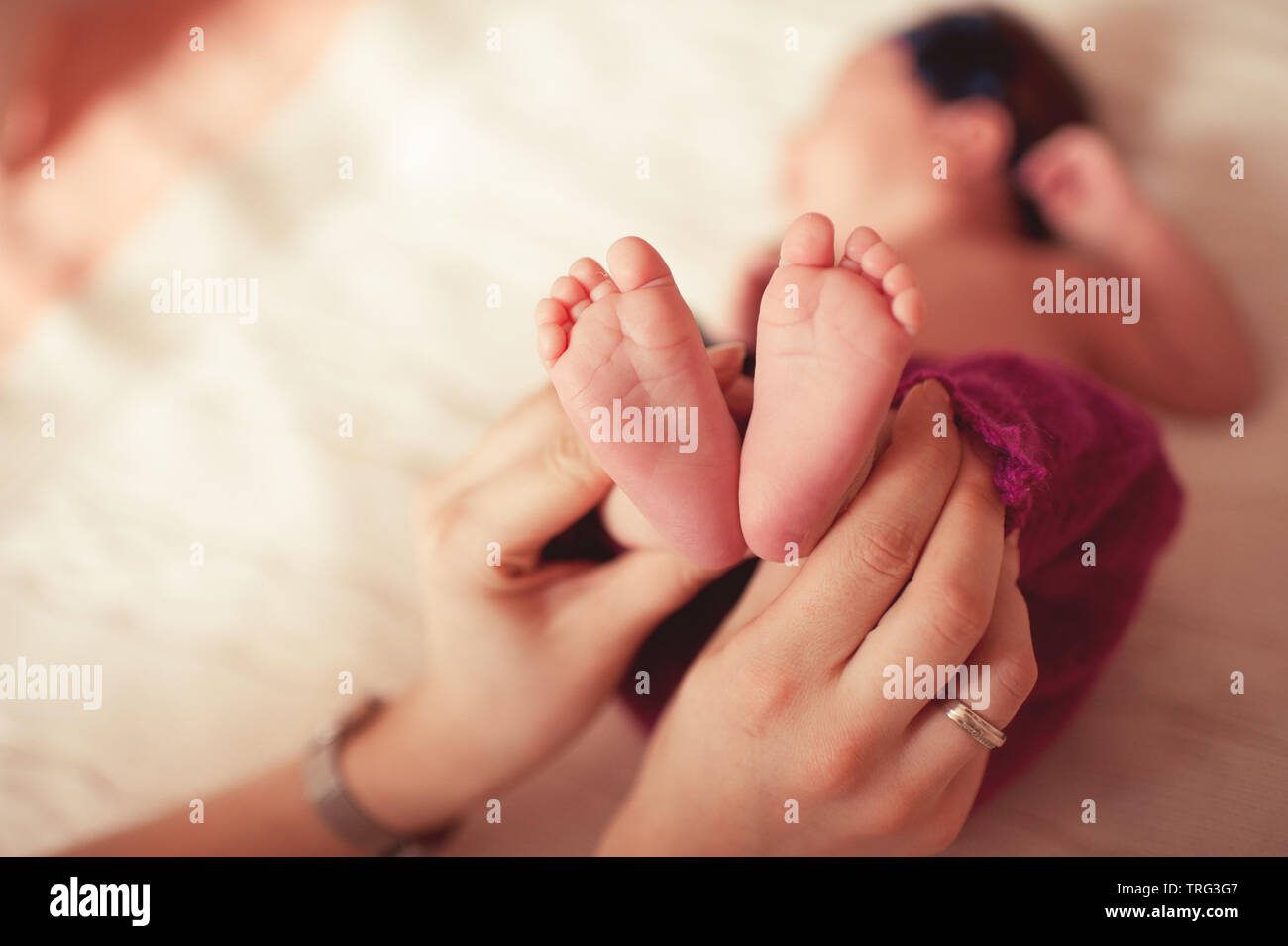 Cute Baby Füße Holding von Müttern, Hände, Nahaufnahme. Die Mutterschaft. Stockfoto