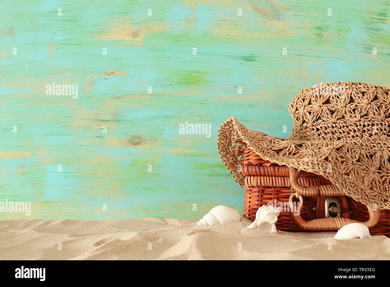 Strand Mode Frauen hat über Stroh Koffer im Sand. Tropischer Sommer Urlaub Konzept Stockfoto