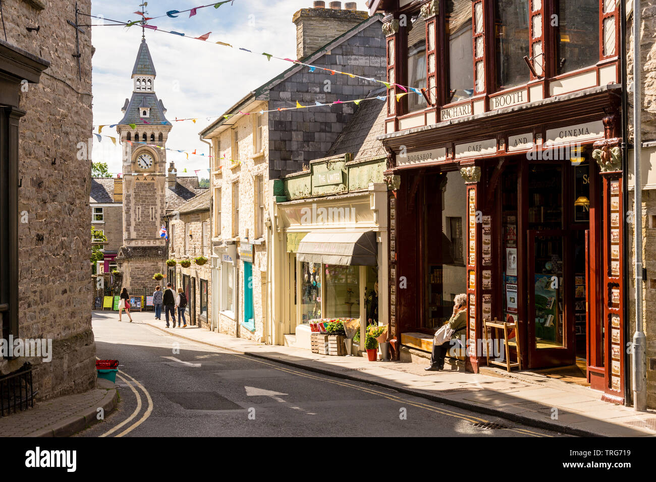 Lion Street, Hay-On-Wye, mit Bunting an einem sonnigen Tag während der Book Festival. Im Preis enthalten sind Richard Booth's Bookshop und der Viktorianischen Uhrturm. Stockfoto