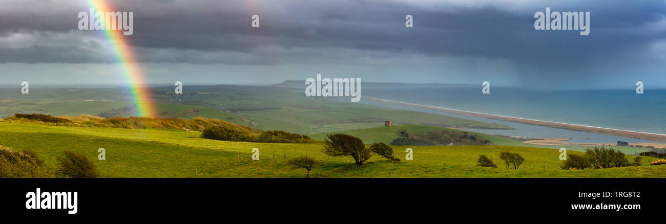 Ein Regenbogen über Abbotsbury, Chesil Beach und Portland, Jurassic Coast, Dorset, England. Stockfoto