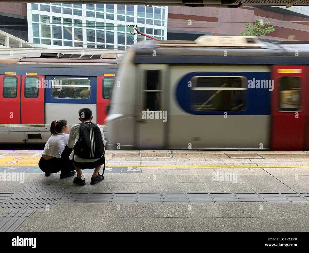 Chinesische Touristen sitzen Warten auf den Zug in Kowloon tong Station Stockfoto