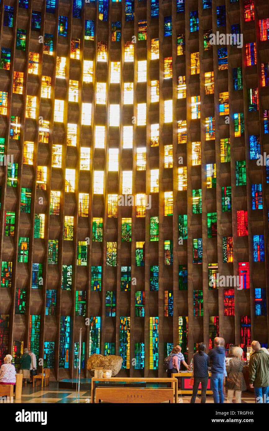 Bunte Glasfenster hinter dem Stein Schrift im Baptisterium der Kathedrale in Coventry, England. Stockfoto