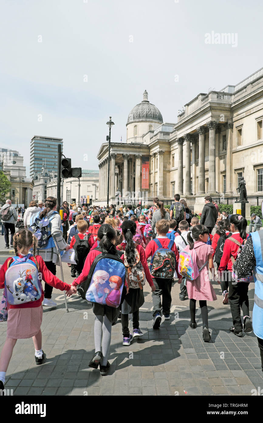 Gruppe der Grundschüler Schüler und Lehrer zu Fuß entlang der Straße der National Gallery London England UK KATHY DEWITT besuchen Stockfoto