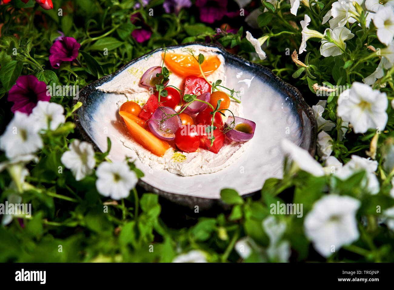 Sommer Salat auf einen Teller unter den Blumen Stockfoto