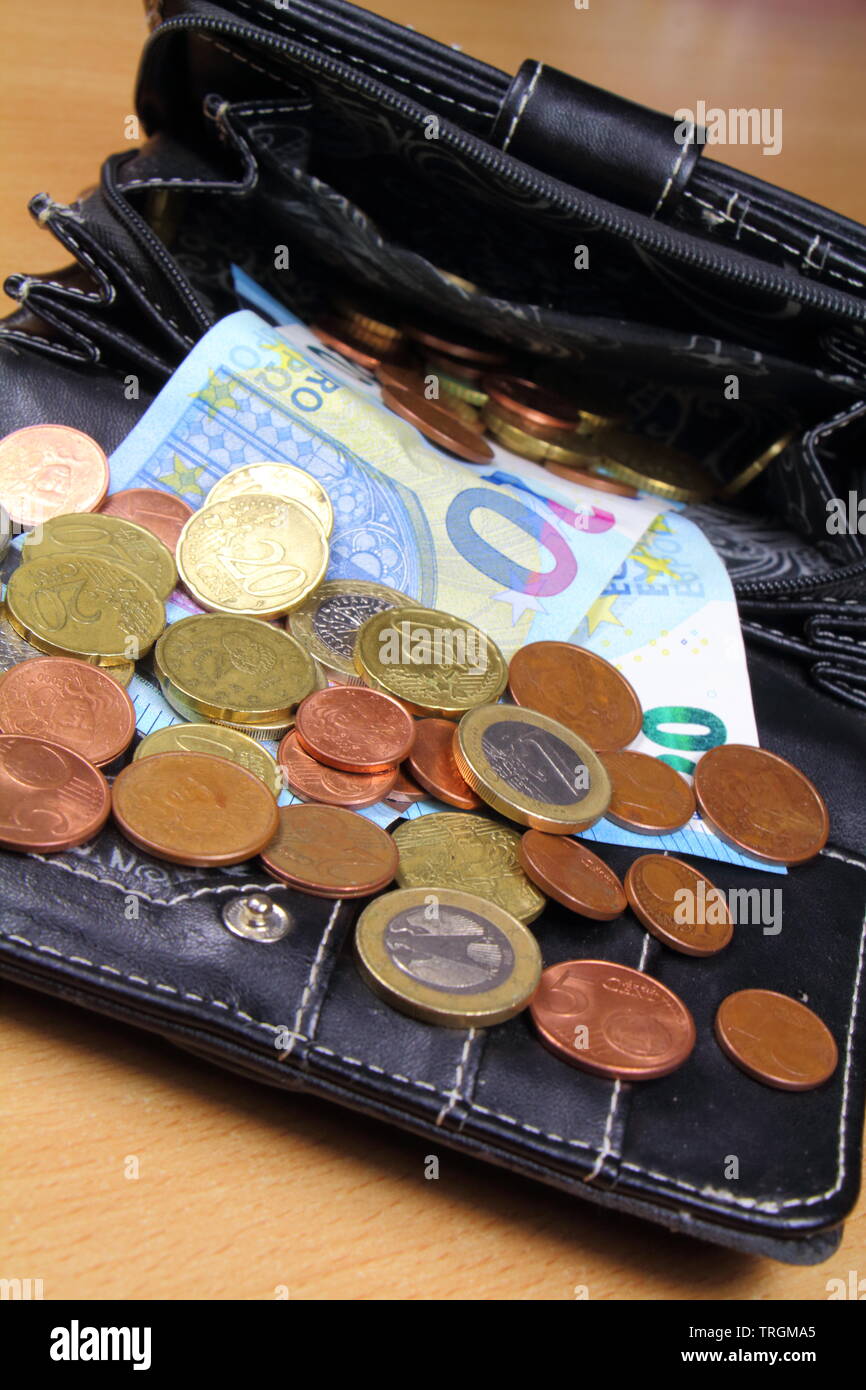 Euro Münzen und Banknoten aus den Geldbeutel in schwarzem Leder Stockfoto