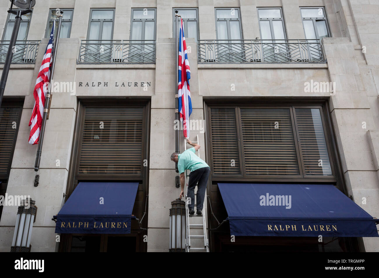 Ein Mitarbeiter erneuert die amerikanischen und britischen Flaggen außerhalb des Amerikanischen Textileinzelhändler Bond Street Adresse, am 5. Juni 2019 in London, England. Außerhalb von American Clothing retailer Ralph Lauren von Bond Street Adresse, am 5. Juni 2019 in London, England. Stockfoto