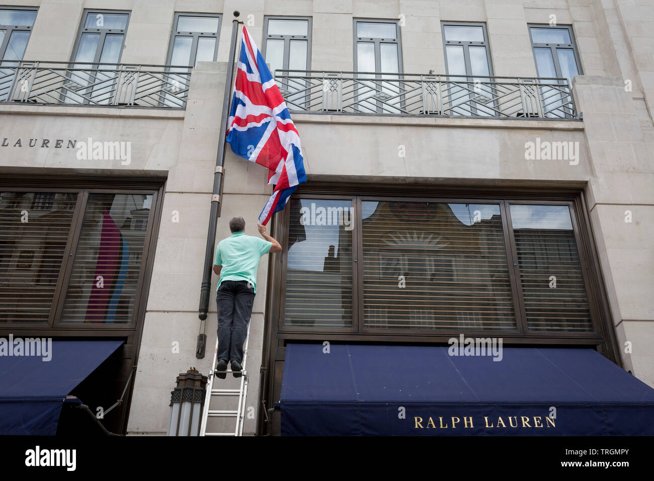 Ein Mitarbeiter erneuert der britischen Union Jack Flagge ausserhalb von American Clothing retailer Ralph Lauren von Bond Street Adresse, am 5. Juni 2019 in London, England. Stockfoto