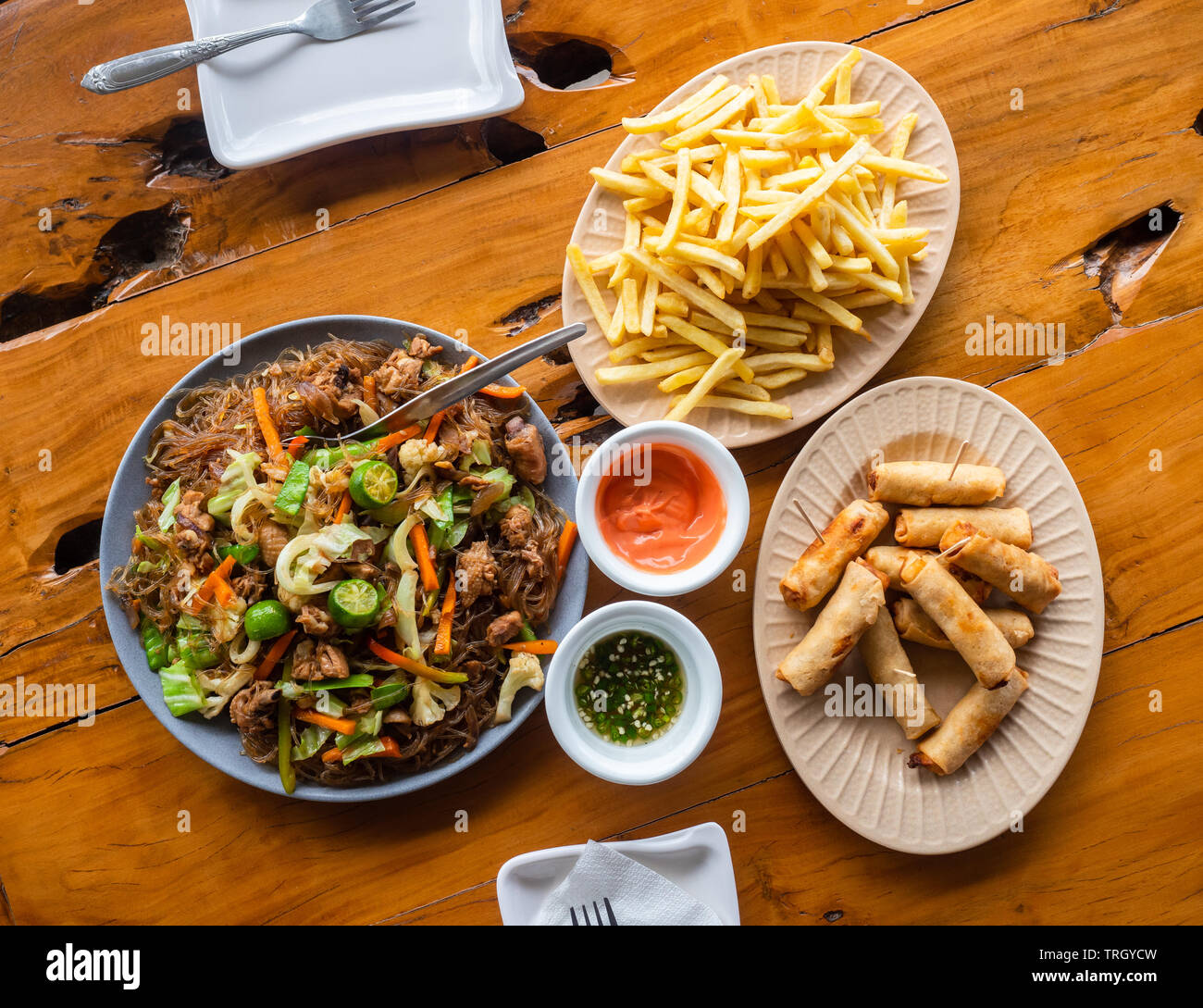 Filipino Mahlzeit, Pancit Sotanghon, Thunfisch Frühlingsrollen und Pommes Frites. Stockfoto