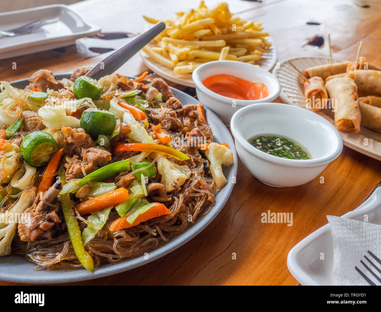 Filipino Mahlzeit, Pancit Sotanghon, Thunfisch Frühlingsrollen und Pommes Frites. Stockfoto