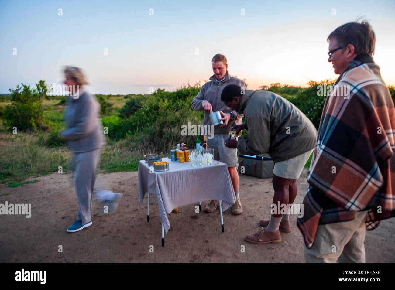 Touristen, Cocktails am Abend, während auf Safari im Phinda Private Game Reserve andBeyond besessen, ein Naturschutzgebiet im östlichen Südafrika. Stockfoto