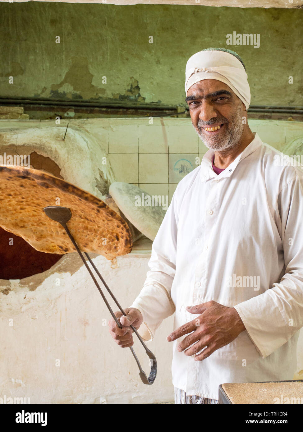 Ein Mann hält bis Naan Brot gebacken in einem traditionellen Holzofen, Tandoori, in Aqda, Iran bekannt. Stockfoto