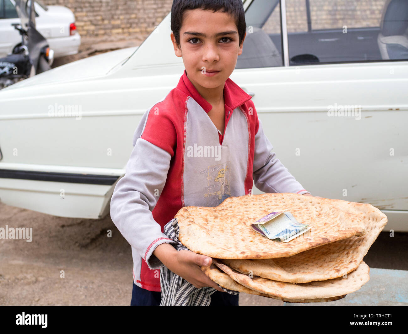 Ein Kind holding Naan Brot am Abend, der traditionellen persischen Brot in einen Tandoori-ton Holzbackofen, in Aqda, Iran. Stockfoto