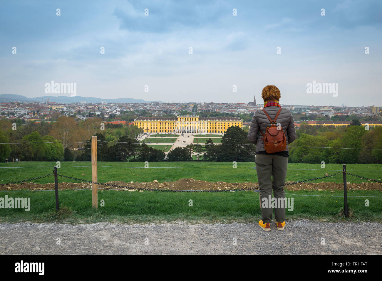 Weibliche Touristin, Rückansicht einer reifen Frau, die im Rucksack auf Schloss Schönbrunn und die Wiener Skyline, Wien, Österreich schaut. Stockfoto