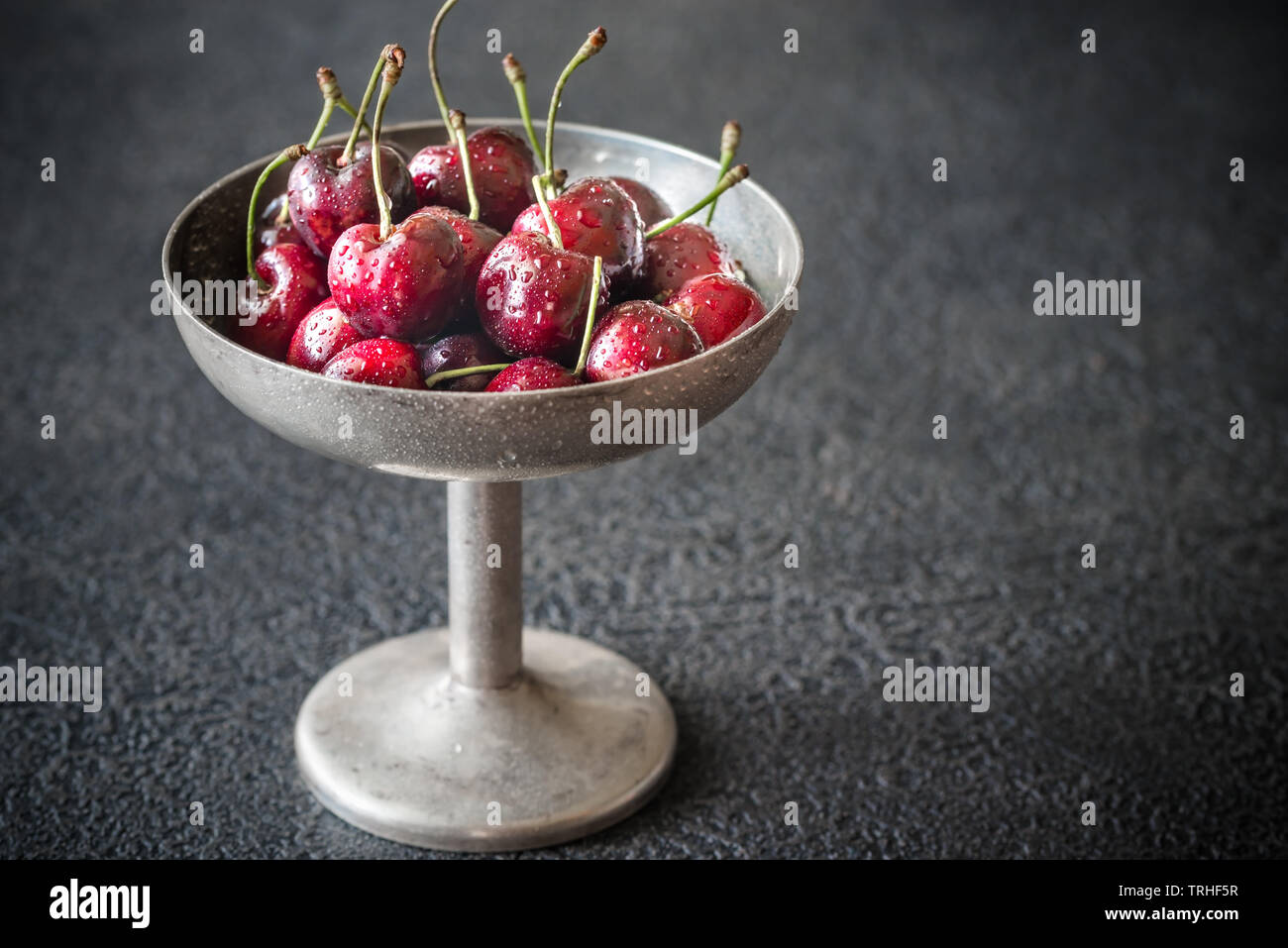 Frische Kirschen in Vintage silver Vase auf dem dunklen Hintergrund Stockfoto