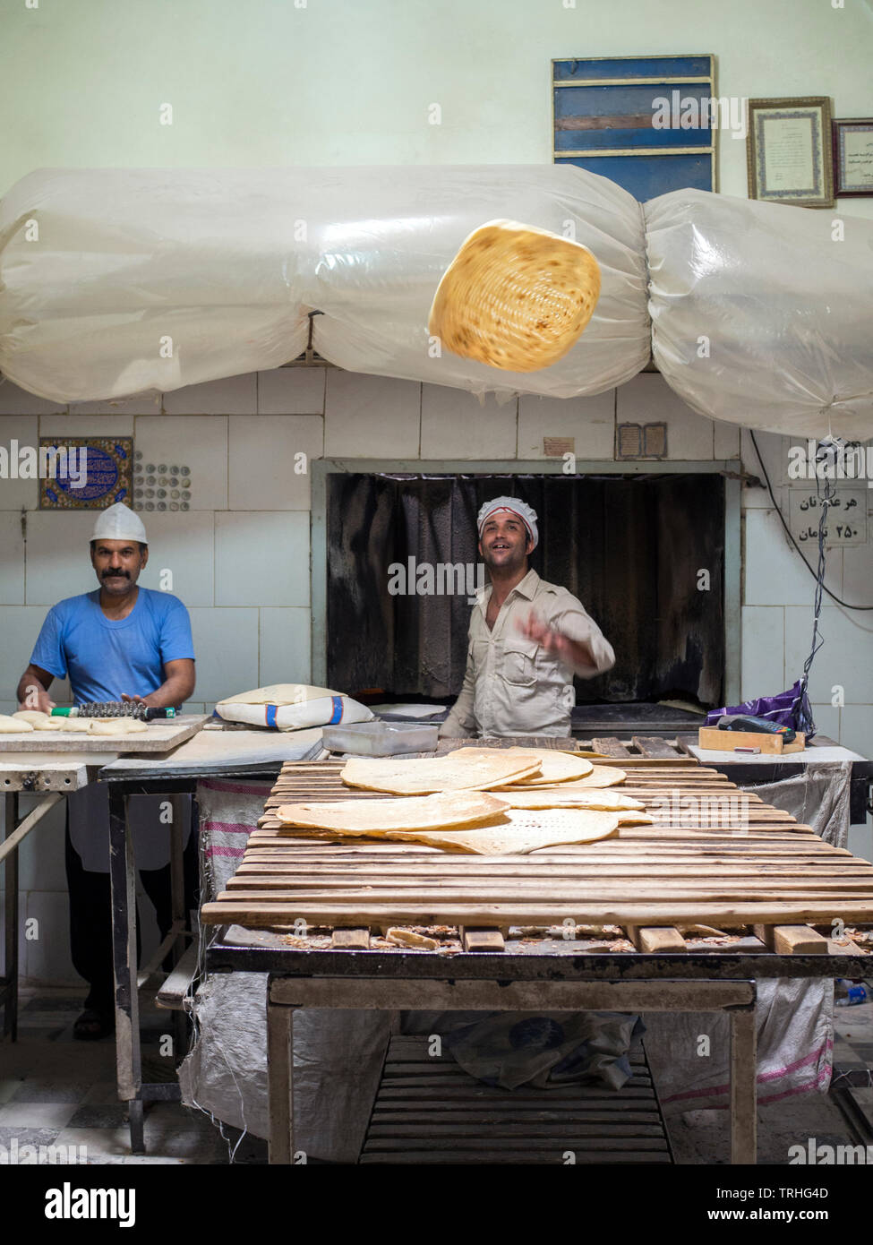 Ein Bäcker wirft eine Festplatte von Naan Brot in die Luft an seiner Bäckerei im Basar, oder Marktplatz, in Yazd, Iran Stockfoto