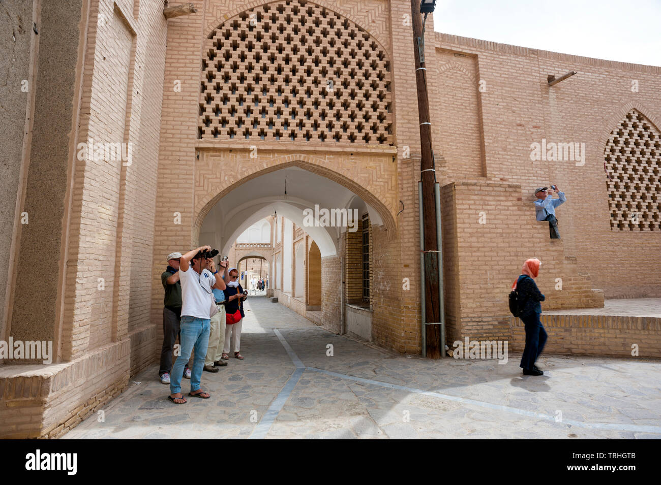 Westliche Touristen in der Altstadt von Naein, eine antike Stadt in der Wüste im Iran. Stockfoto