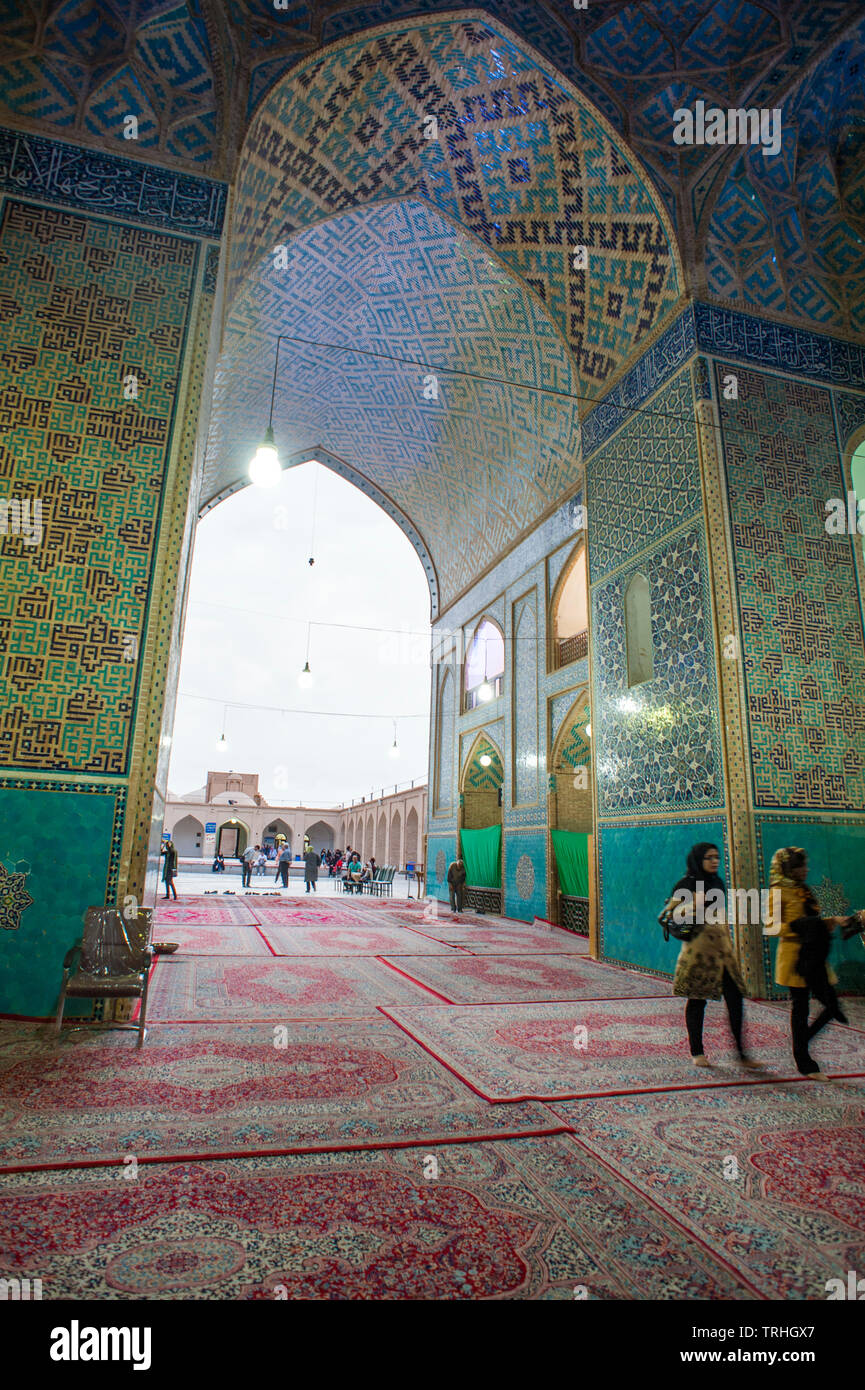 Touristen wandern im 14. Jahrhundert Masjid-e Jame Moschee in Yazd, Iran. Die Moschee ist für seine kunstvollen Mosaiken berühmt. Stockfoto