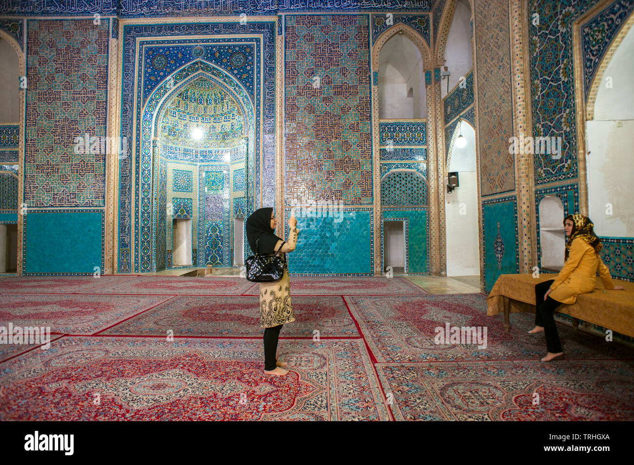Touristen im 14. Jahrhundert Masjid-e Jame Moschee in Yazd, Iran. Die Moschee ist für seine kunstvollen Mosaiken berühmt. Stockfoto