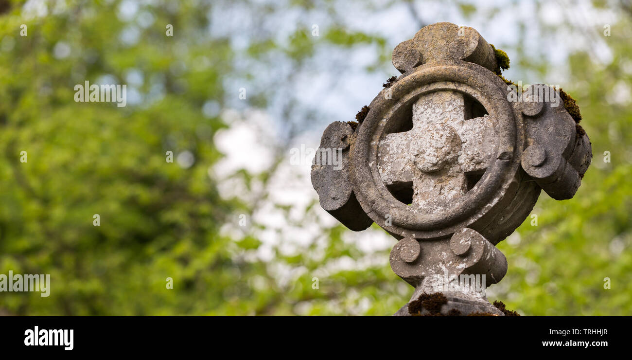 In der Nähe von alten steinernen Kreuz, an einem Friedhof befindet. Die Bäume im Hintergrund. Freier Platz für Text, Card Format. Religiöses Symbol. Gott, spirituelle Stockfoto