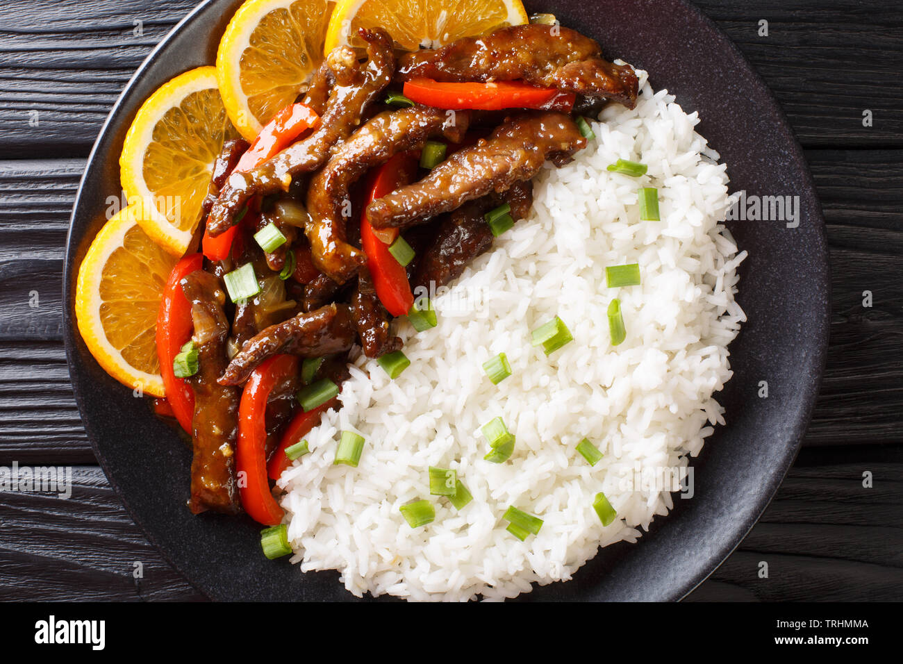 Asiatische Rindfleisch Rühren braten mit Paprika in Soja orange Sauce mit Reis close-up auf einem Schild auf dem Tisch serviert. horizontal oben Ansicht von oben Stockfoto