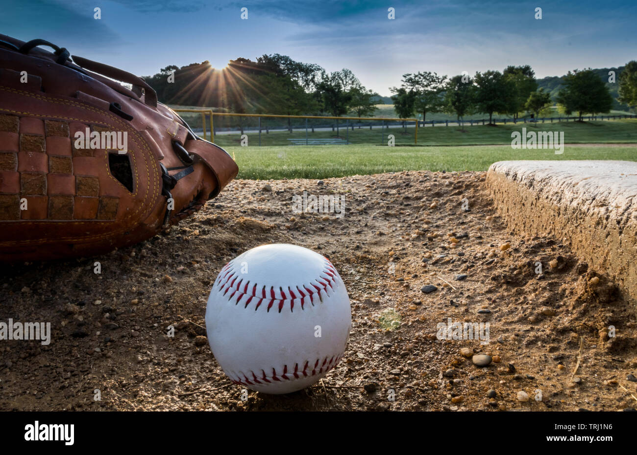Baseball und Handschuh auf Krüge Damm am frühen Morgen Frühling Stockfoto