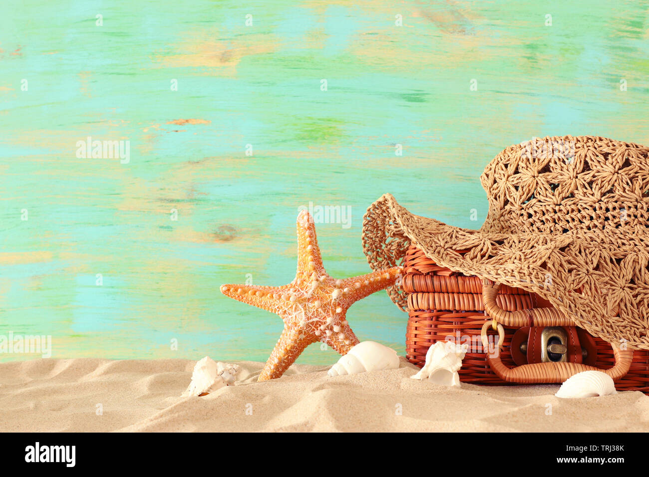 Strand Mode Frauen hat über Stroh Koffer im Sand. Tropischer Sommer Urlaub Konzept Stockfoto