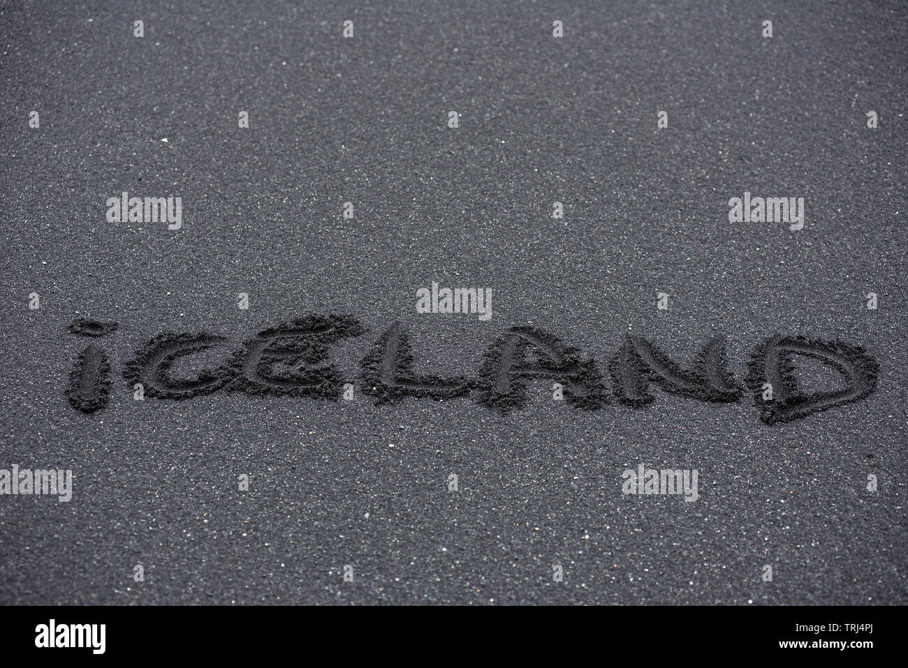 Island Wort handschriftlich auf den schwarzen Strand sand Stockfoto