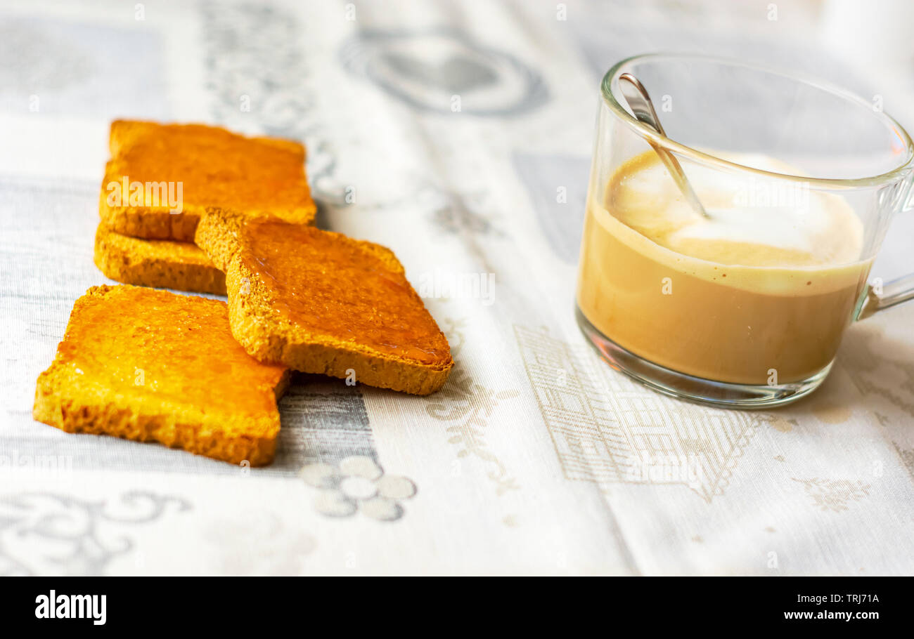 Gruppe der Kekse mit Marmelade mit einer Tasse Cappuccino verteilt auf eine Tabelle mit den dekorierten Tischdecke. Frühstück am Morgen. Gesunde Ernährung und Lebensstil Stockfoto