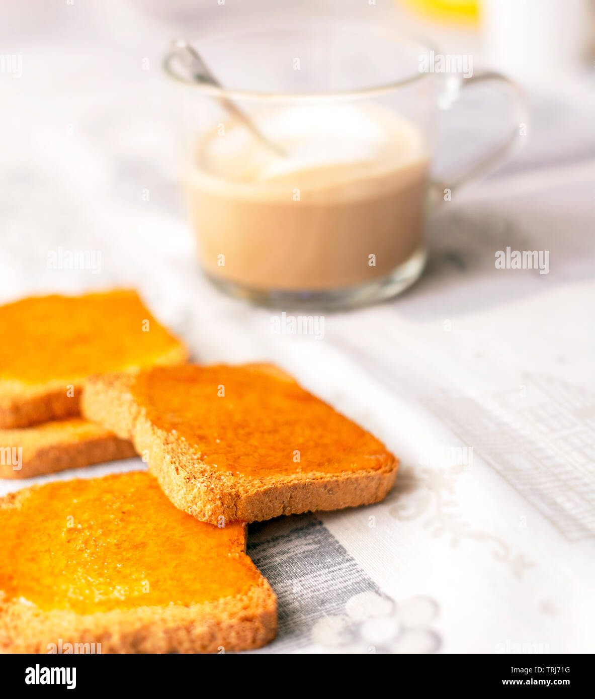 Gruppe der Kekse mit Marmelade mit einer Tasse Cappuccino verteilt auf eine Tabelle mit den dekorierten Tischdecke. Frühstück am Morgen. Gesunde Ernährung und Lebensstil Stockfoto