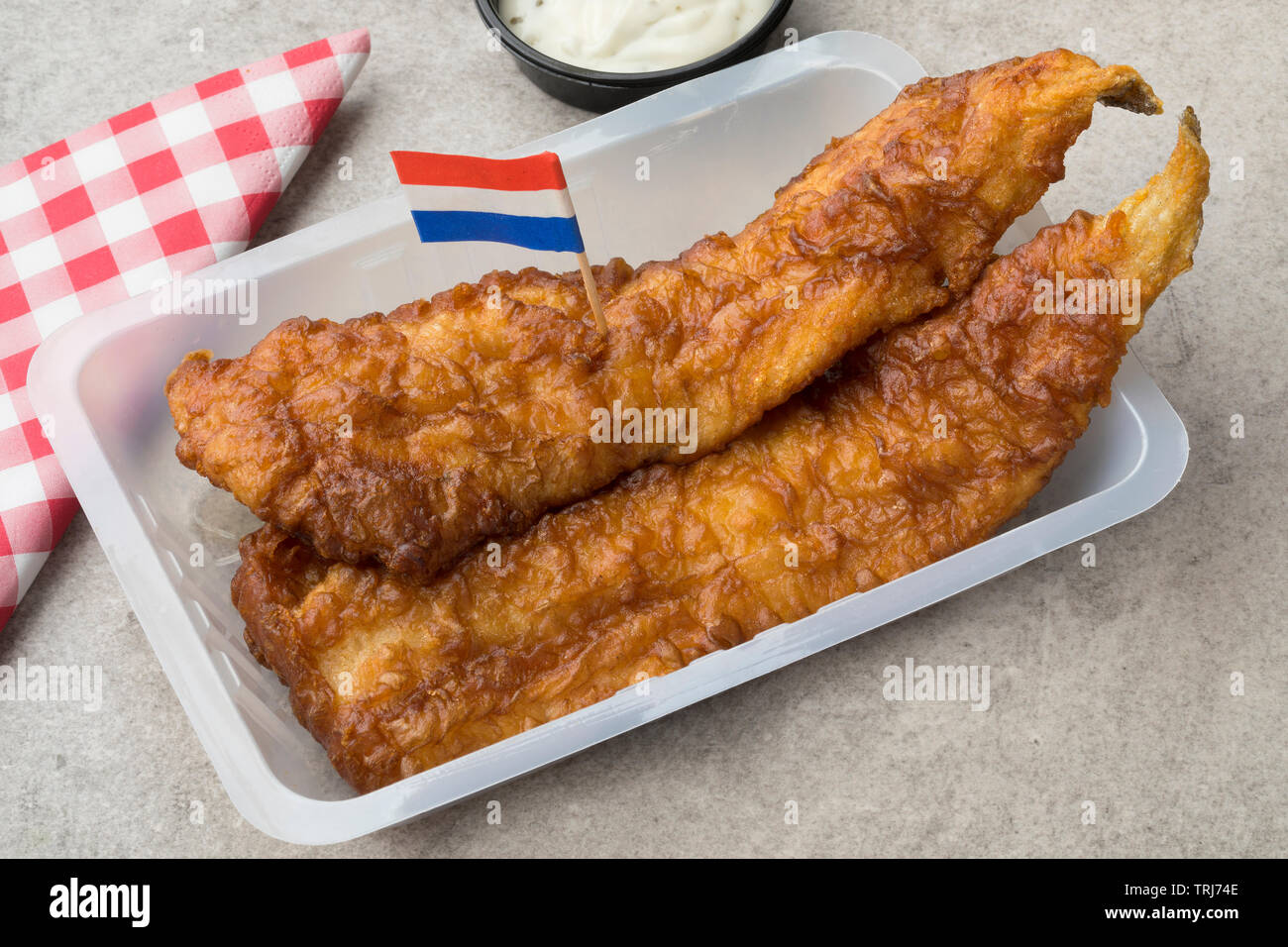 Frittierter Fisch Filet, genannt lekcurbek in Niederländisch mit Soße und ein niederländischer Flagge serviert. Stockfoto