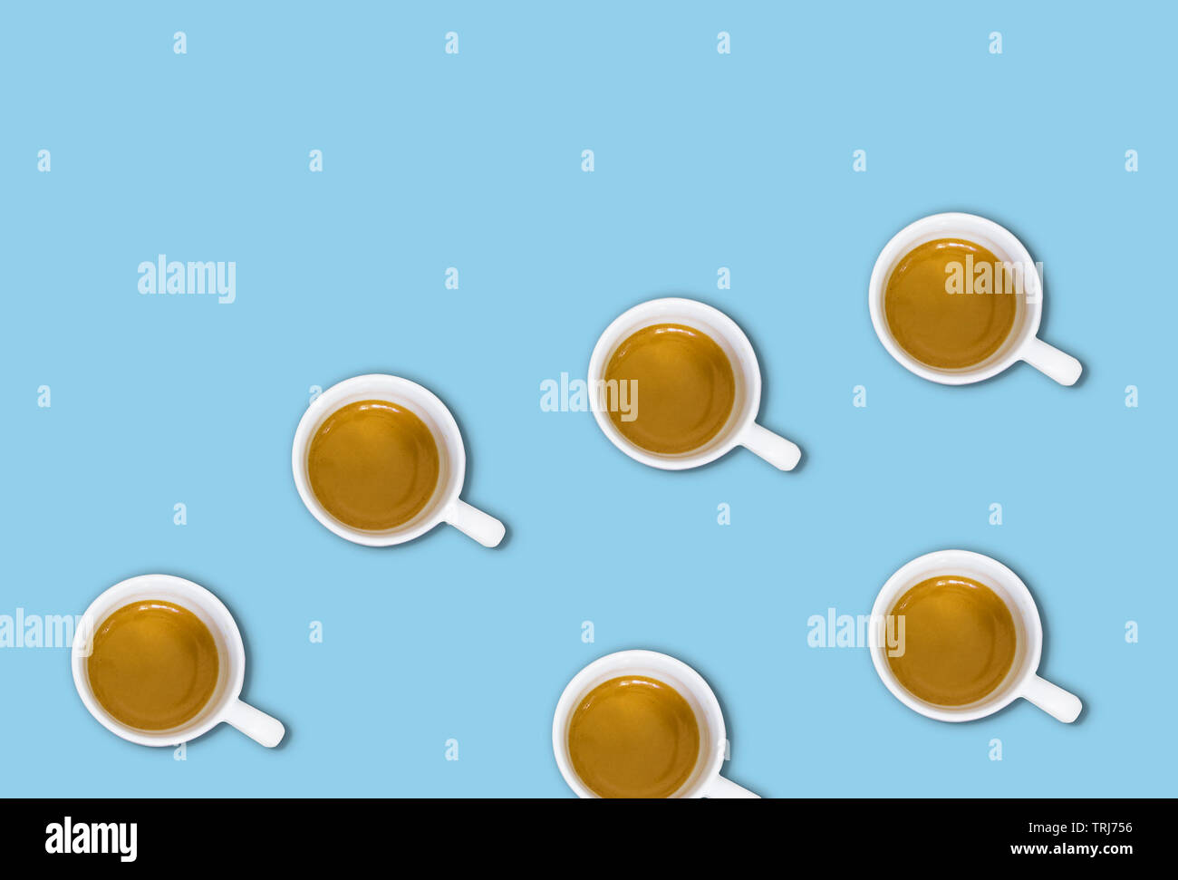 Minimalistische Muster mit einem Blick von oben auf eine Gruppe von Kaffeetassen auf einem Hellblau pastell Tabelle. Flach Fotografie Stockfoto