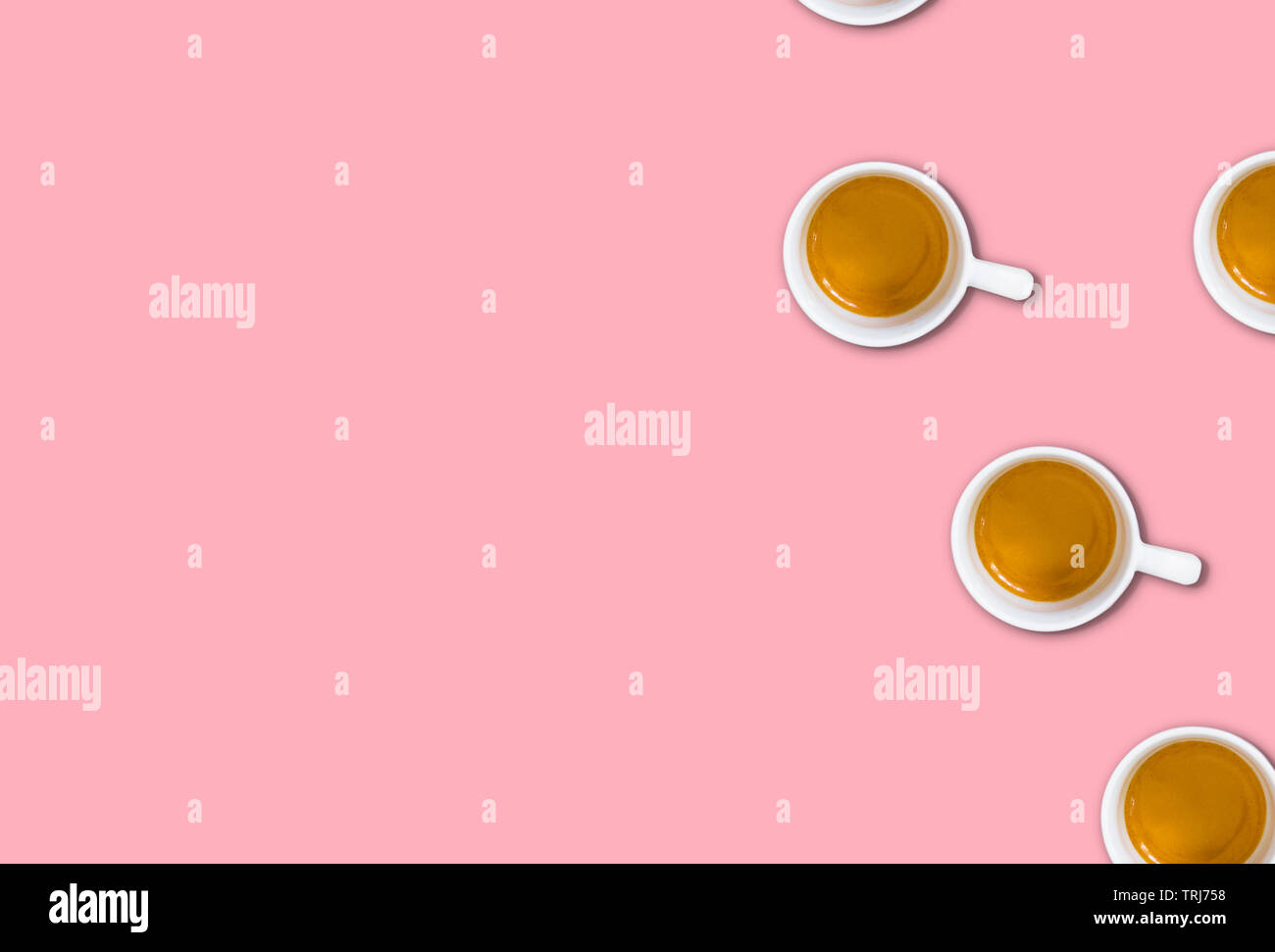 Minimalistische Muster mit einem Blick von oben auf eine Gruppe von Kaffeetassen auf einem hellen Rosa pastell Tabelle. Flach Fotografie Stockfoto