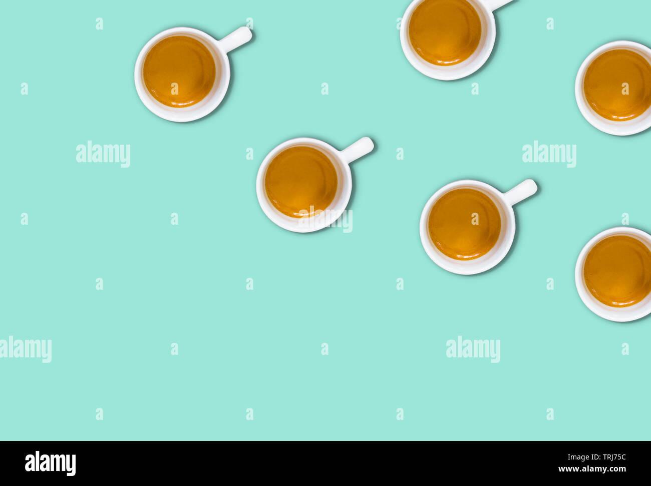 Minimalistische Muster mit einem Blick von oben auf eine Gruppe von Kaffeetassen auf einem Hellgrün pastell Tabelle. Flach Fotografie Stockfoto