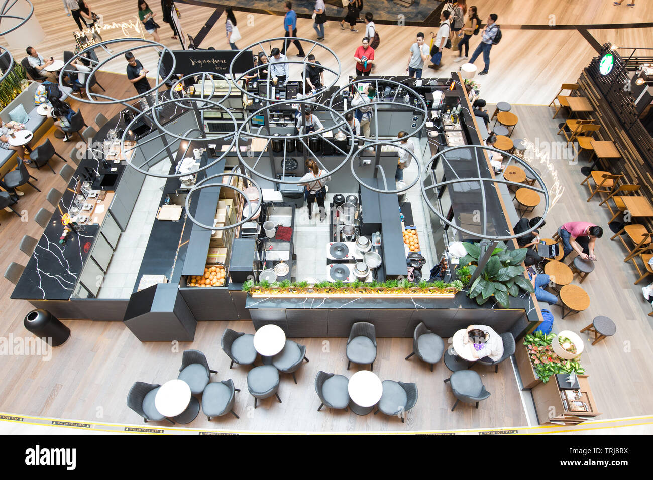 Blick aus der Vogelperspektive auf eine Café-Küche mit Personal, das wartende Gäste bedient. Jewel Changi Airport, Singapur Stockfoto