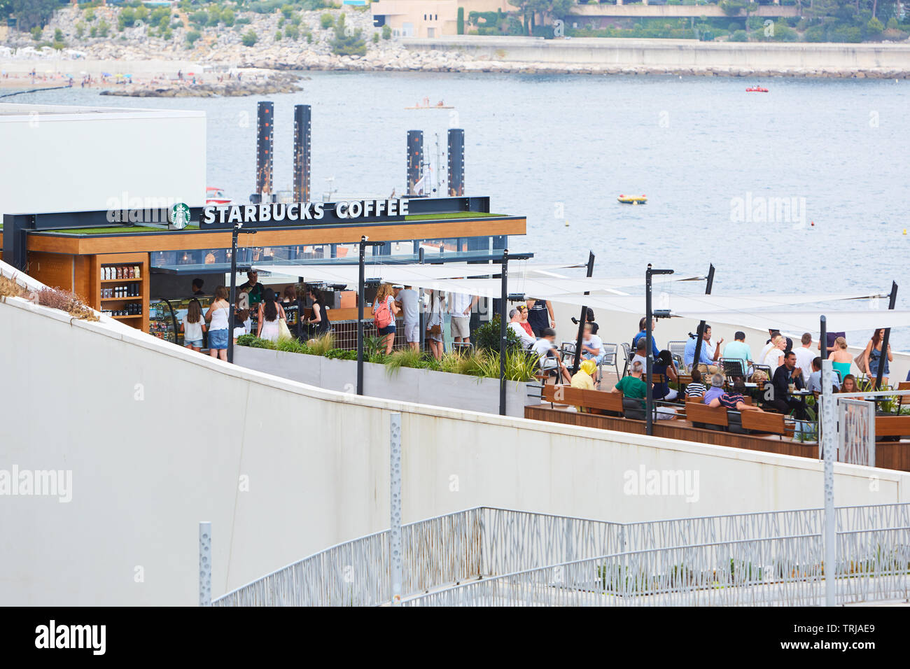 MONTE CARLO, MONACO - 19. AUGUST 2016: Kaffee von Starbucks Cafe Terrasse mit Menschen im Sommer in Monte Carlo, Monaco. Stockfoto