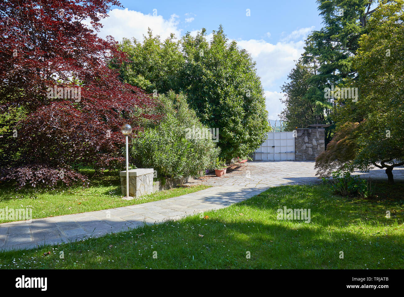 Garten mit Stein Fliesen- Pfad und Gericht in einem sonnigen Sommertag, Italien Stockfoto