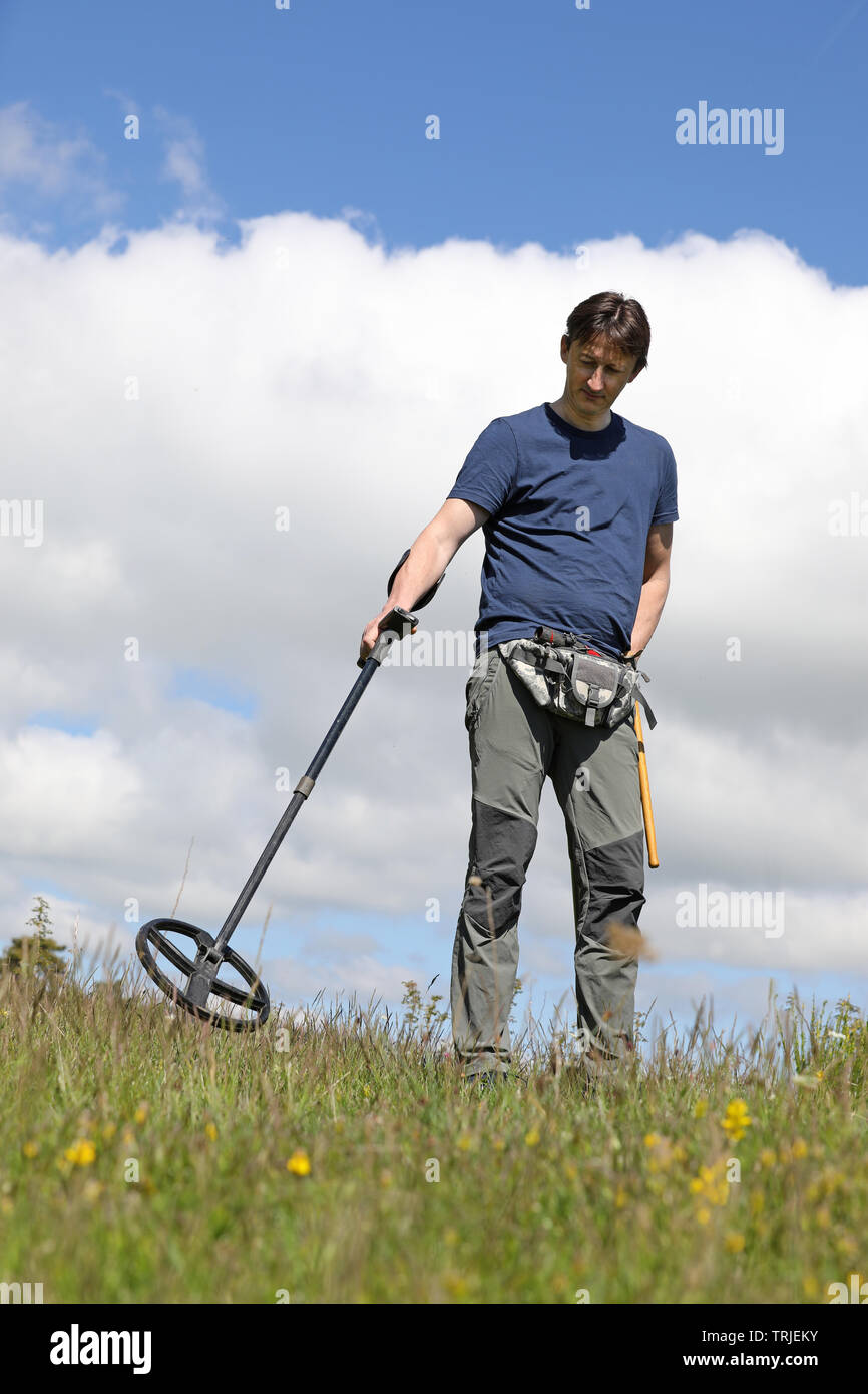 Ein Mann auf der Suche nach vergrabenen schatz, antike Münzen und historischen Artefakte mit Metalldetektor Stockfoto