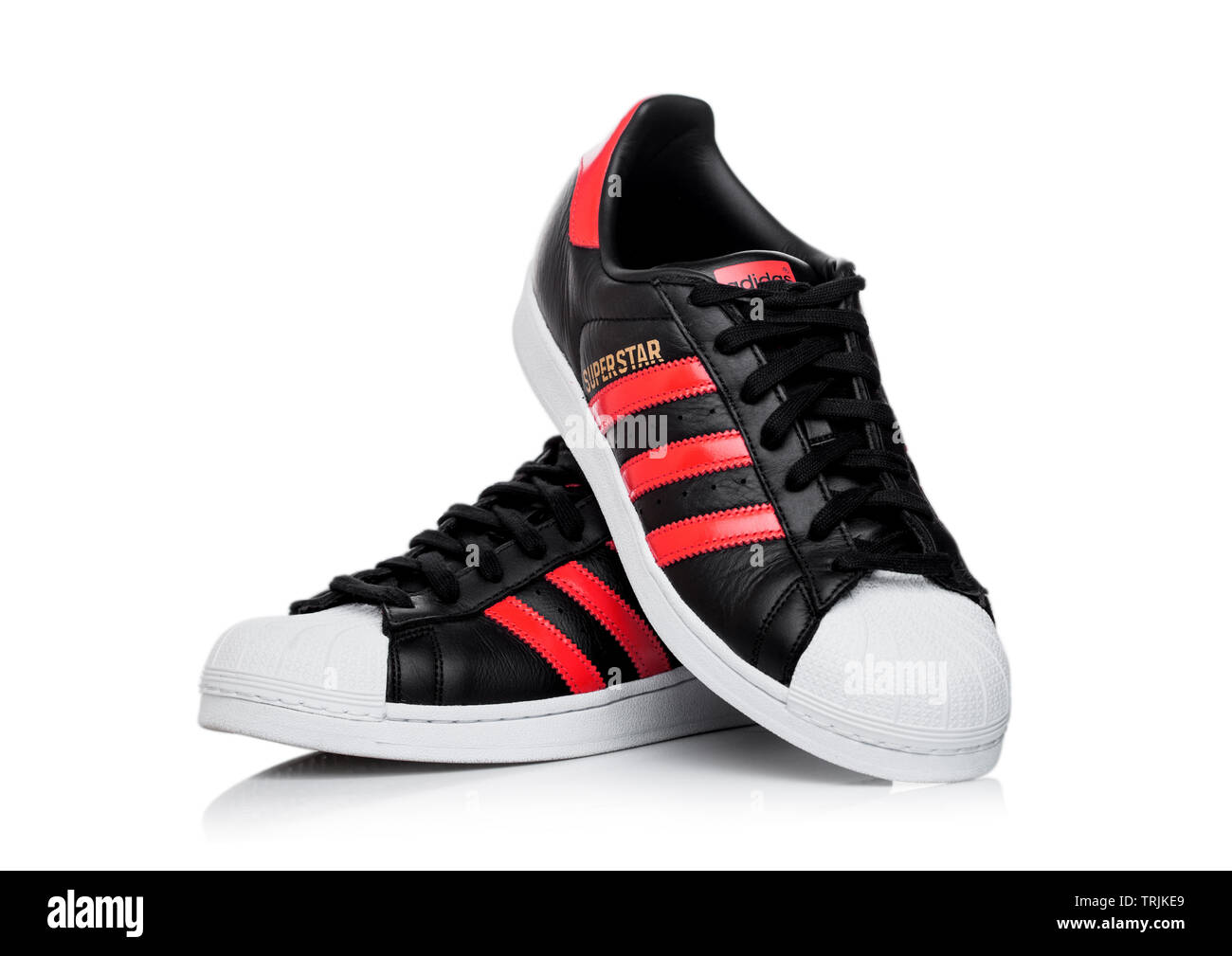 LONDON, UK - Juni 05, 2019: Adidas Superstar schwarze Schuhe mit roten  Streifen auf weißem Hintergrund Stockfotografie - Alamy