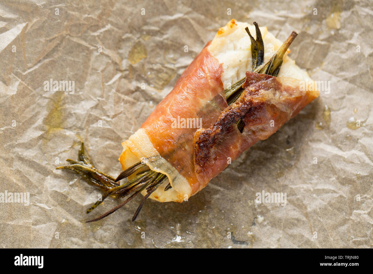 Ein frisch zubereitetes Rinderfilet pollack Pollachius pollachius, dass in Zitronensaft und zerdrückten Knoblauch, bevor in Parmaschinken eingewickelt zu werden, mariniert worden ist Stockfoto