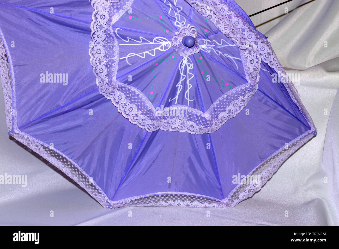 Ist ein Kind niedlich Lila lacy Regenschirm auf Stoff angezeigt. Es wird gut sein, an einem regnerischen oder sonnigen Tag in Missouri zu haben. Stockfoto