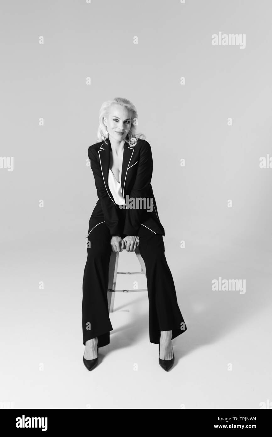 Studio Portrait von schöne blonde Frau in einem schwarzen Kleid gegen Weiße einfachen Hintergrund Stockfoto