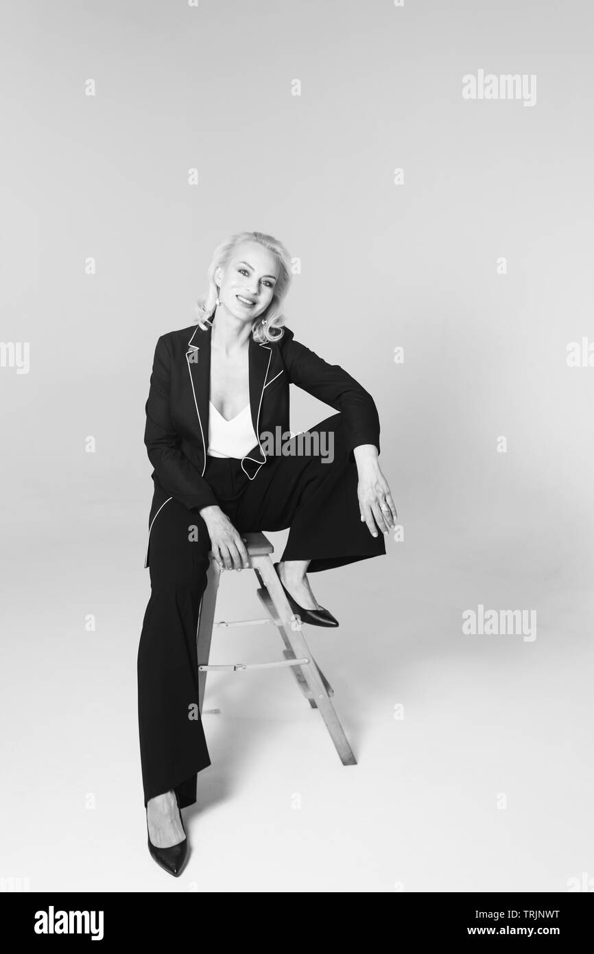 Studio Portrait von schöne blonde Frau in einem schwarzen Kleid gegen Weiße einfachen Hintergrund Stockfoto