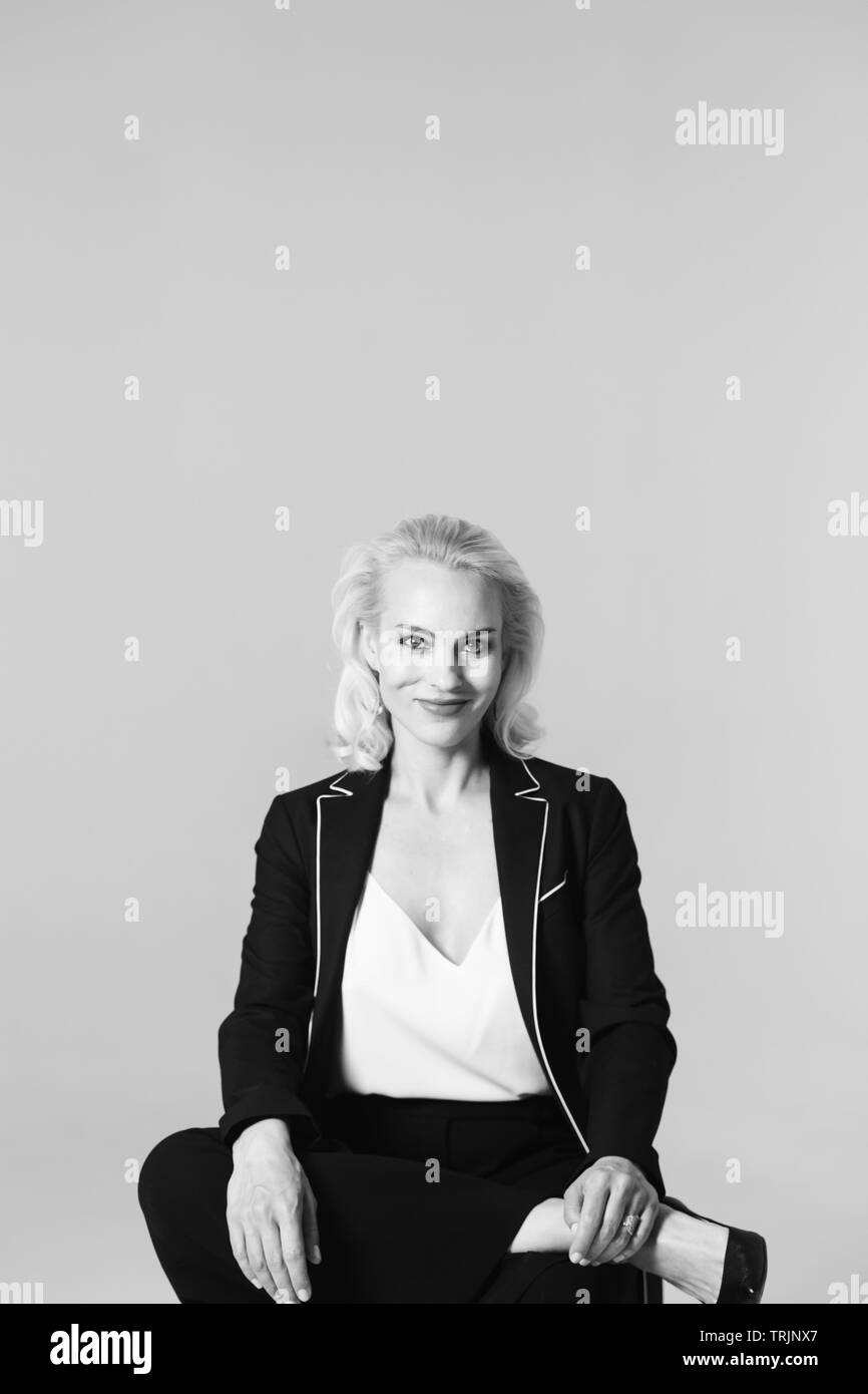 Studio Portrait von schöne blonde Frau in einem schwarzen Kleid gegen Weiße einfachen Hintergrund Stockfoto