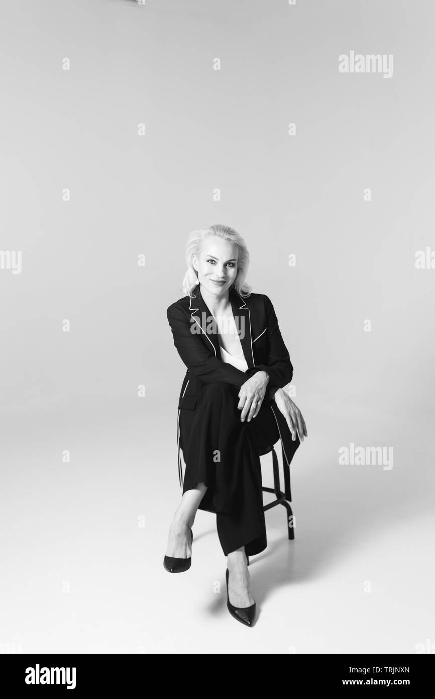 Studio Portrait von schöne blonde Frau in einem schwarzen Kleid gegen Weiße einfachen Hintergrund Stockfoto