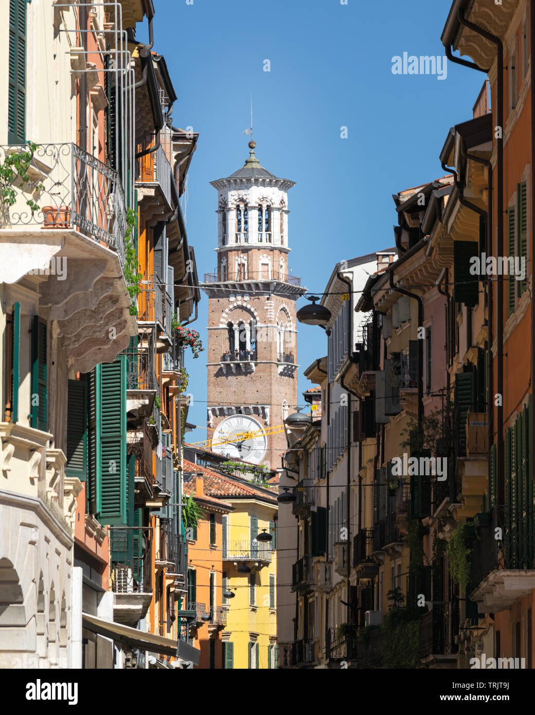 Torre Dei Lamberti durch die Straßen von Verona von der Piazza Bra, Italien auf einem hellen Sommertag mit blauen Himmel gesehen Stockfoto