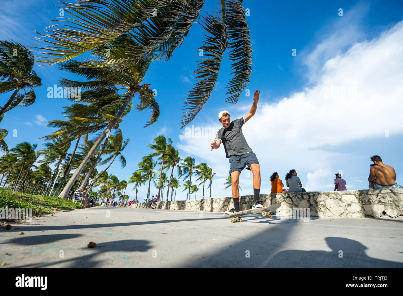 MIAMI - Dezember 27, 2017: Ein junger Mann fährt mit dem skateboard entlang der Strandpromenade Promenade Promenade am Lummus Park in South Beach. Stockfoto